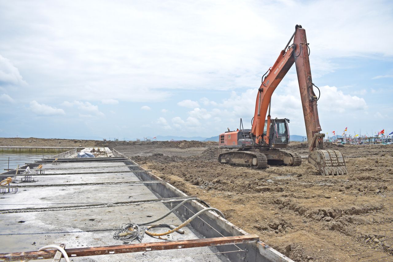 Services A large excavator machine working at an open construction site during the day.